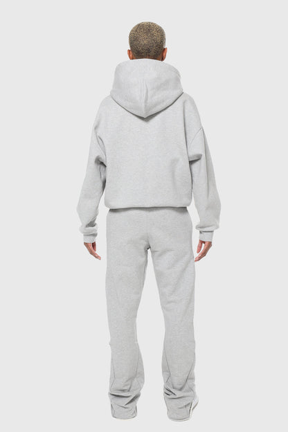 Unisex zip-up hoodie in pure grey, made from 100% organic cotton with a minimalist design, featuring durable double Riri zippers for added functionality and style. Crafted in Britain for a sustainable, premium look, perfect for streetwear styling and versatile enough to pair with both casual and elevated outfits.